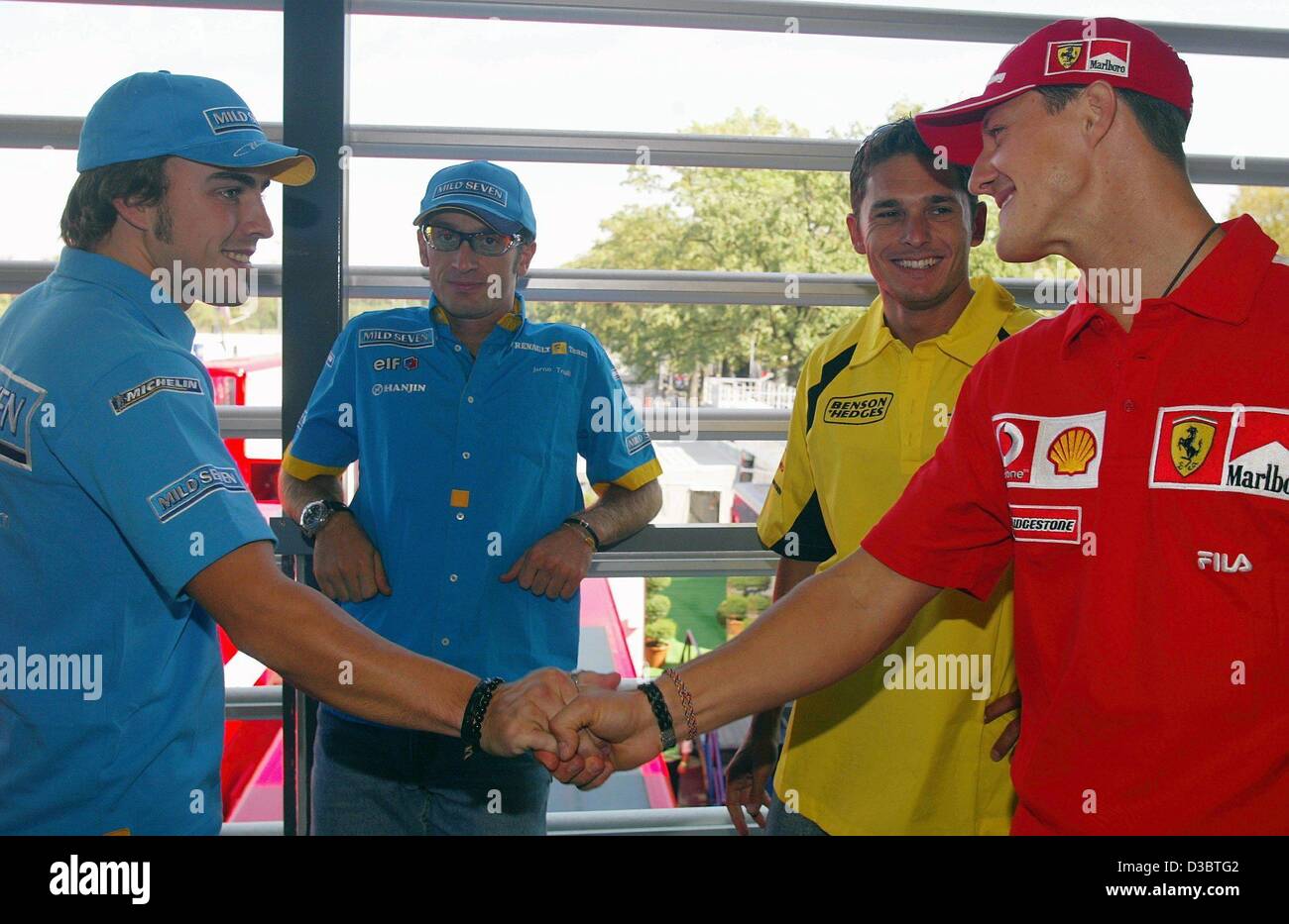 (dpa) - German formula one champion Michael Schumacher (R) of Ferrari and Spain's Fernando Alonso (L) of Renault shake hands while Italian formula one pilots Jarno Trulli of Renault (2nd from L) and Giancarlo Fisichella of Jordan-Ford look on, at the race track in Monza, Italy, 11 September 2003. Th Stock Photo