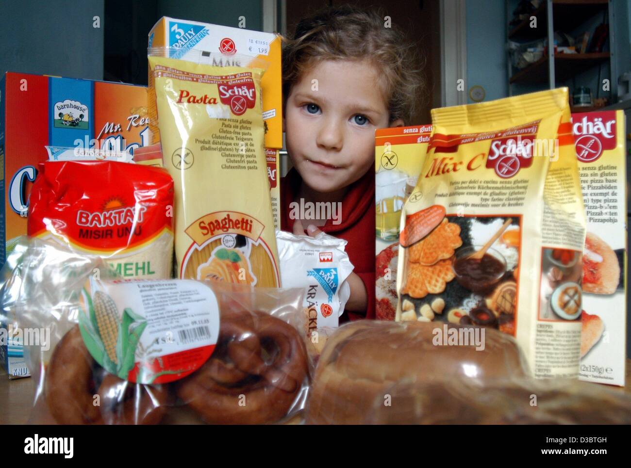 (dpa) - The five-year-old Marie Stock sits among gluten-free products bought at a health food shop in Frankfurt, Germany, 30 August 2003. Marie suffers from celiac disease and cannot eat food containing gluten, the protein which is contained in most of the grains. Therefore she has to eat pasta, noo Stock Photo