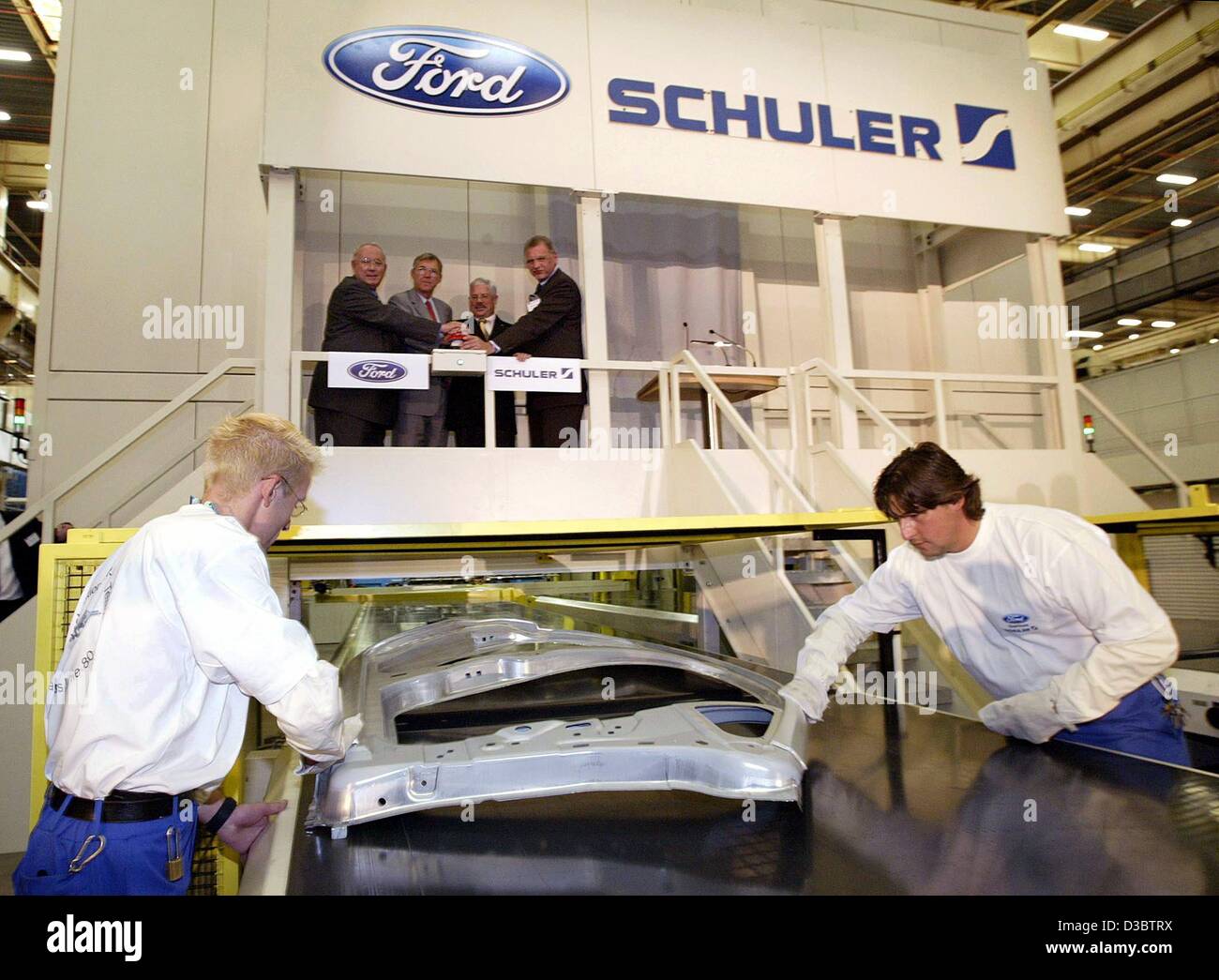 (dpa) - The director of the car making unit of Ford Europa, Hans Schardt (top L), the Economy Minister of the state of Saarland Hanspeter Georgi, Mayor of Saarlouis Hans-Joachim Fontaine and a board member of the Schuler group, Wilfried Jakob, press the button to start the new Compact Crossbar Trans Stock Photo