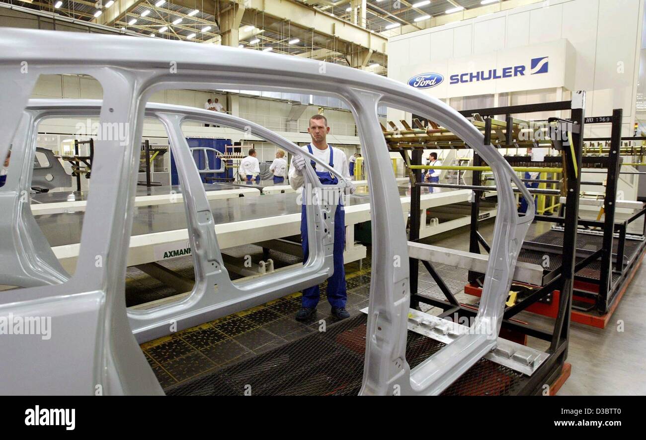 (dpa) - A Ford employee lifts up a side body part of a Ford Focus C-Max from the new Compact Crossbar Transfer Press at the Ford facilities in Saarlouis, Germany, 4 September 2003. With the press, entire side body parts of the Ford Focus C-Max can be manufactured. The press, manufactured by the Schu Stock Photo