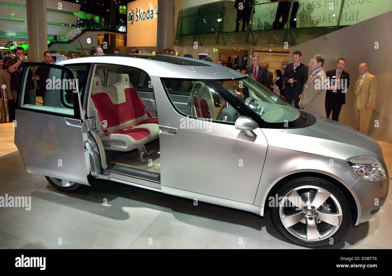 dpa) - Groups of visitors look at the Skoda Roomster at the stand