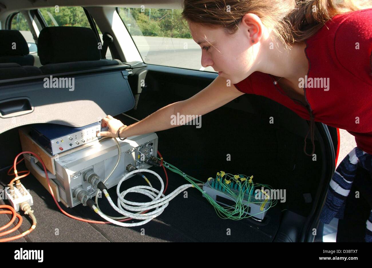 (dpa) - Intern Mirja Kuehne installs a temperature reader in a Ford Mondeo at the testing ground at the development centre of the Ford factury in Cologne, Germany, 3 September 2003. The young woman is participating in the 'Try-Ing' internship programme for women which introduces her to the professio Stock Photo