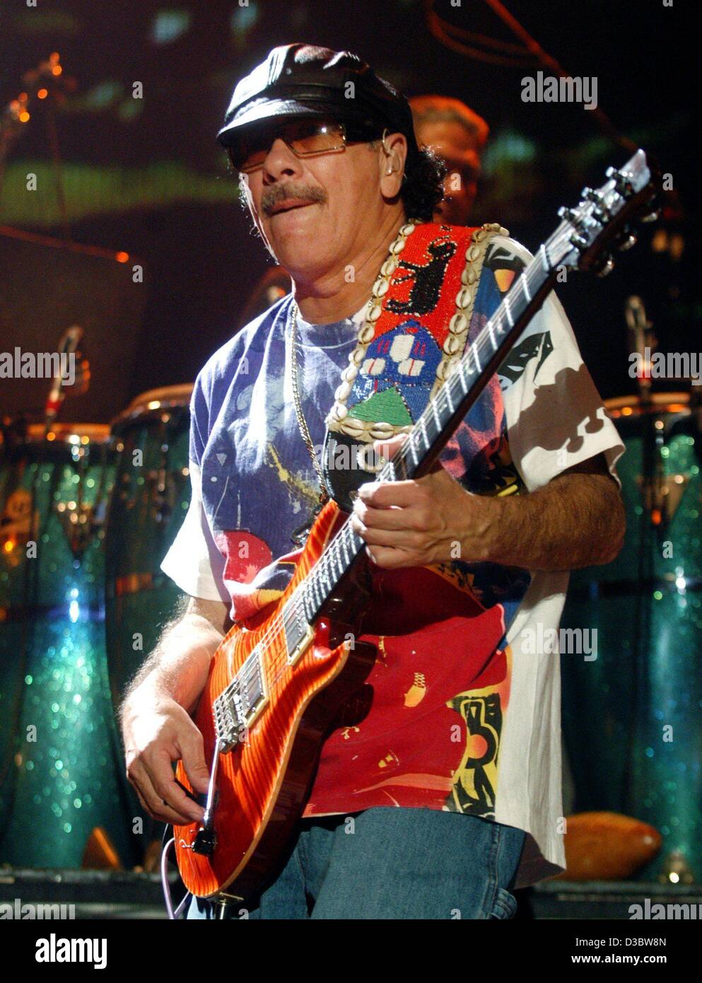 dpa) - Mexican guitar virtuoso Carlos Santana plays his guitar during the  concert in Hamburg, 2 September 2003. The 56-year-old musician enthused  thousands of fans on the first concert of his Germany