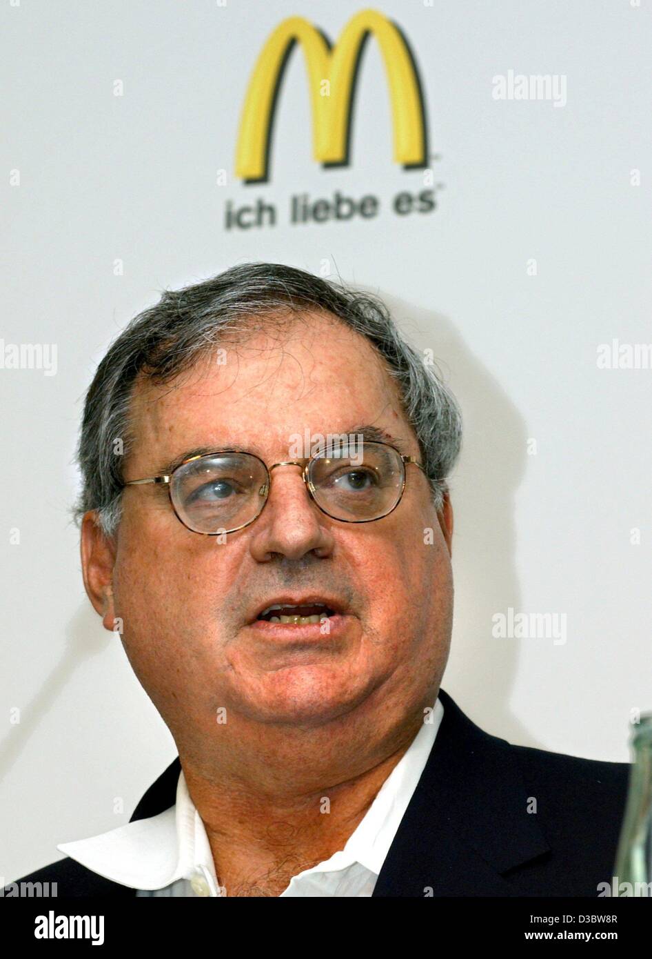(dpa) - Larry Light, Vice President of the fast food chain McDonald's, poses in front of the new logo during a press conference in Munich, 2 September 2003. The slogan 'ich liebe es' ('i'm lovin' it') will soon make its way into the vocabulary of McDonald's customers in more than 100 countries as th Stock Photo