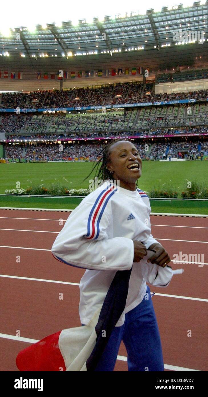 (dpa) - French athlete Eunice Barber jubilates and runs an honourary round with her national flag after winning the women's long jump competition of the 9th IAAF Athletic World Championships at the Stade de France in Paris, 30 August 2003. She wins gold with a jump of 6.99 m. Stock Photo