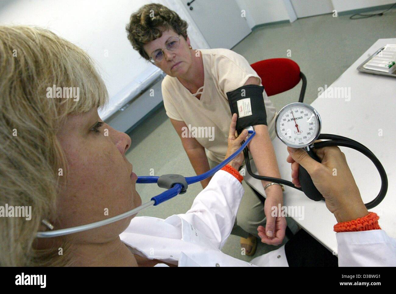 (dpa) - Doctor Birgit Dassow (L) takes the blood pressure of patient Ilona Fieber at a practice in Magdeburg, Germany, 21 August 2003. The envisaged healthcare reform of the German government will result in deep cuts in the health and welfare systems. Germany's expensive healthcare system which is f Stock Photo