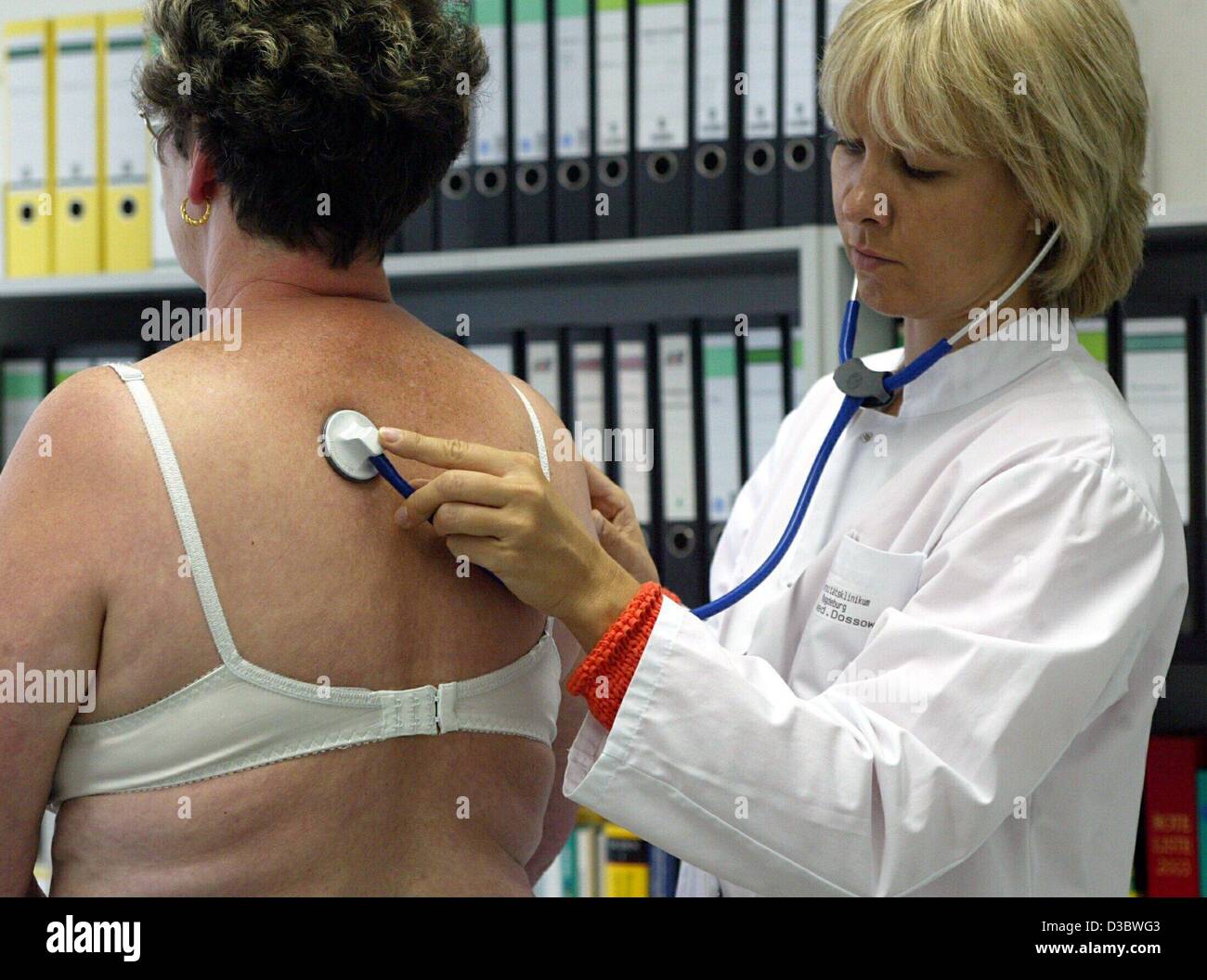 (dpa) - Doctor Birgit Dassow (R) listens to the breathing of patient Ilona Fieber at a practice in Magdeburg, Germany, 21 August 2003. The envisaged healthcare reform of the German government will result in deep cuts in the health and welfare systems. Germany's expensive healthcare system which is f Stock Photo