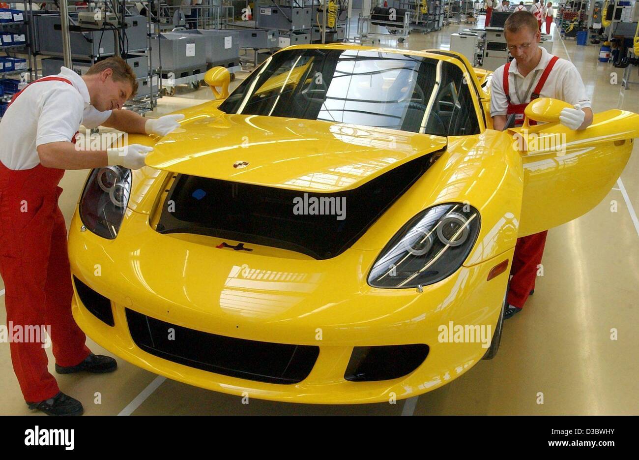 (dpa) - Tilo Becker (L) and Carsten Otto work on the first models of the Porsche Carrera GT at the Porsche factory in Leipzig, Germany, 28 August 2003. The first models are expected to be delivered this autumn. The Carrera will be the race car for the road: it has 612 hp, reaching a maximum speed of Stock Photo
