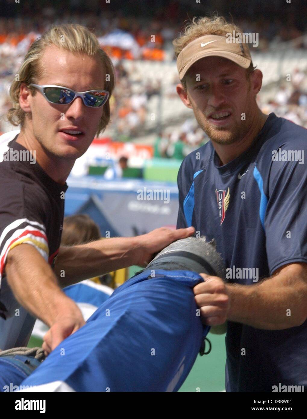 (dpa) - Germany's Andre Niklaus (L) and his US opponent Tom Pappas (R) bag their poles after the pole vault competition of the decathlon event at the 9th IAAF Athletic World Championships at the Stade de France in Paris, 27 August 2003. Pappas wins the decathlon with a total score of 8750 points, Ni Stock Photo