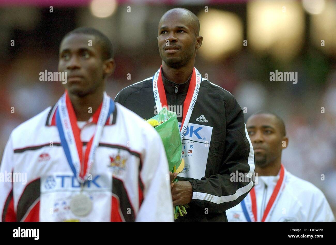 (dpa) - The winners of the men's 100 m sprint, silver-medal winner Darrel Brown from Trinidad and Tobago (front), gold-medal winner Kim Collins from Saint Kitts and Nevis (C) and third-placed Darren Campbell from Britain, pose with their medals on the podium at the 9th IAAF Athlectic World Champions Stock Photo