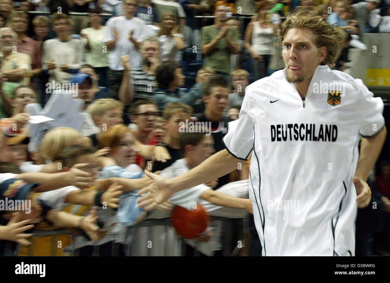 (dpa) - Germany's basketball player Dirk Nowitzki wearing the Germany tricot runs along the gym past his fans ahead of the Supercup game opposing Germany and France in Brunswick, Germany, 24 August 2003. France wins the game 76-68. The Supercup 2003 is a tournament between France, Croatia, Sweden an Stock Photo