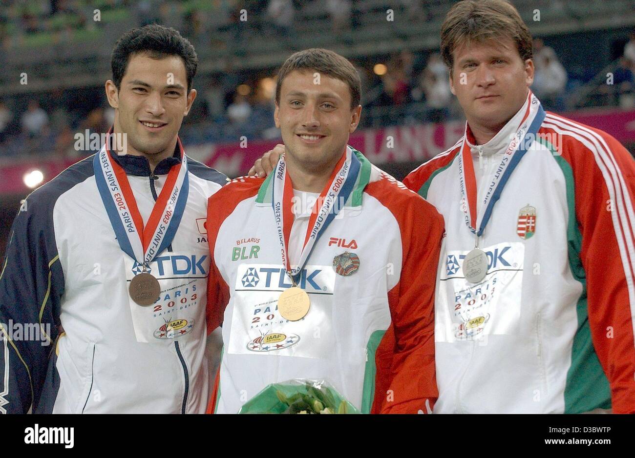 (dpa) - Hammer throw gold medal winner Ivan Tikhon of Belarus is flanked by second placed Hungarian Annus Adrian (R) and third placed Japanese Koji Murofushi (L) during the podium ceremony at the 9th IAAF Athlectic World Championships at the Stade de France in Paris, 25 August 2003. Stock Photo
