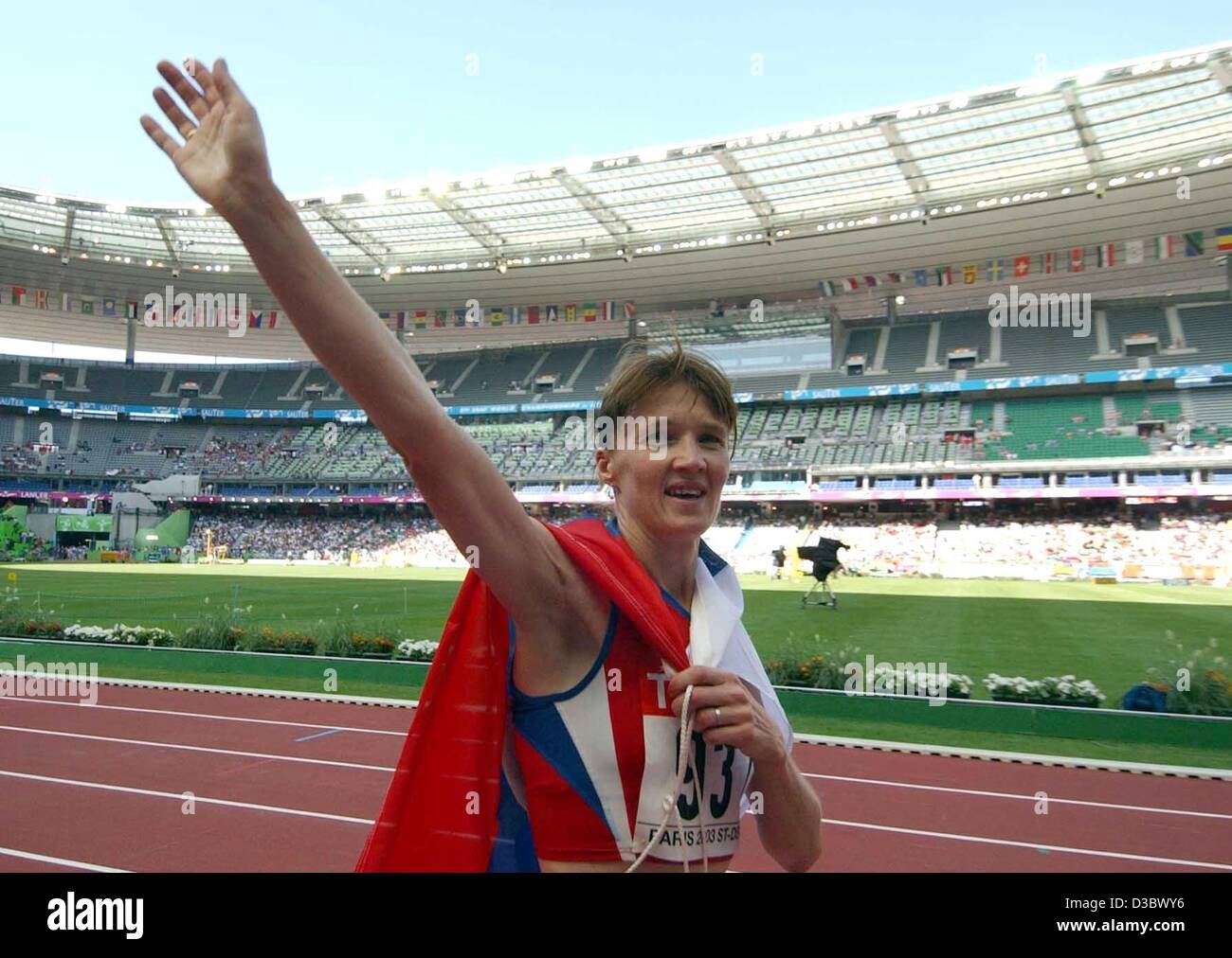 (dpa) - Russian walker Yelena Nikolayeva carries the Russian flag and waves after her victory in the women's 20 km walk event at the 9th IAAF Athletic World Championships at the Stade de France in Paris, 24 August 2003. Stock Photo