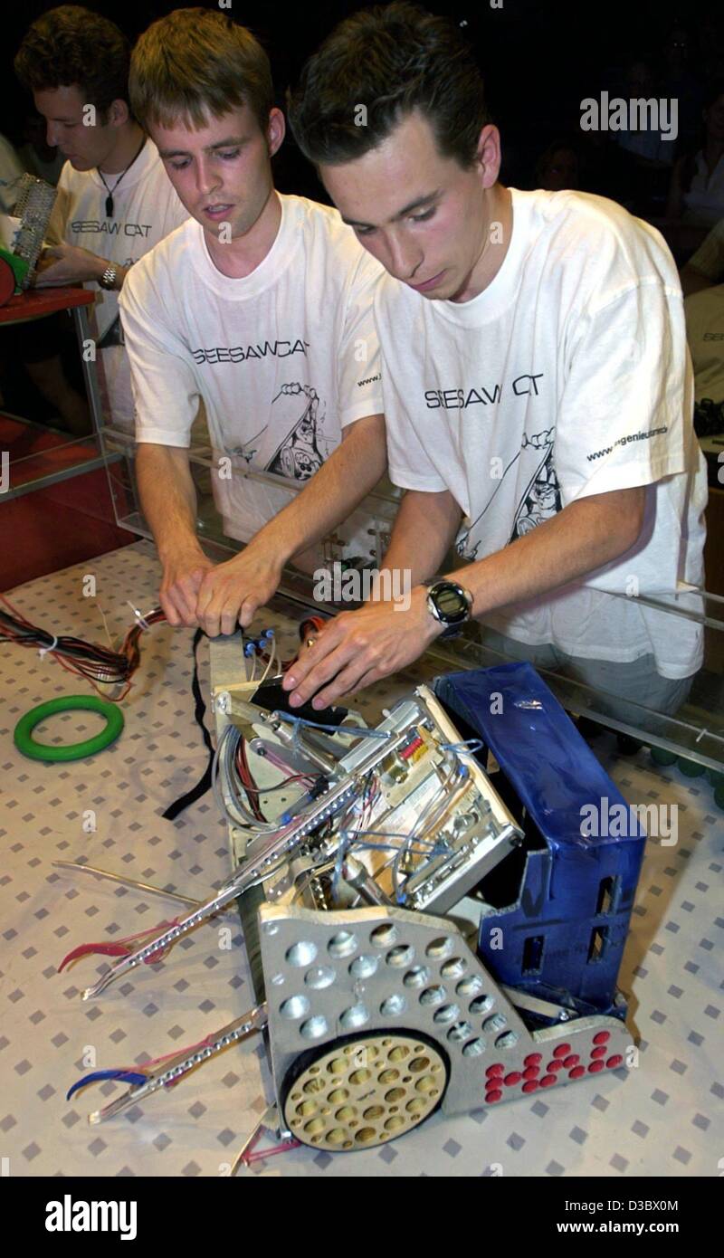 (dpa) - Tammo Behrend (L) and Fridolin Lander (R), both students in the fourth semester at the technical university in Darmstadt, wire their robot Hal for the final competition International Design Contest 2003 in Darmstadt, Germany, 28 June 2003. For the twelfth time students assembled remote-contr Stock Photo