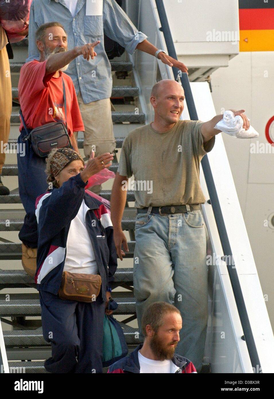 (dpa) - The released Sahara hostages Kurt Schuster (red shirt), Erna Schuster (L below) and Juergen Matheis (R) point at their relatives as they arrive at Cologne airport, Germany, 20 August 2003. In the foreground below the freed hostage Martin Hainz. A German Air Force jet carrying 14 Europeans wh Stock Photo