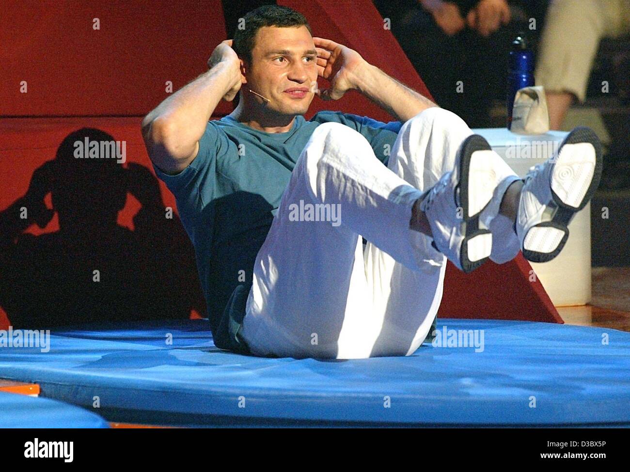 (dpa) - Ukrainian boxer Vitali Klitschko makes sit-ups during a TV show in Munich, 16 August 2003. Stock Photo