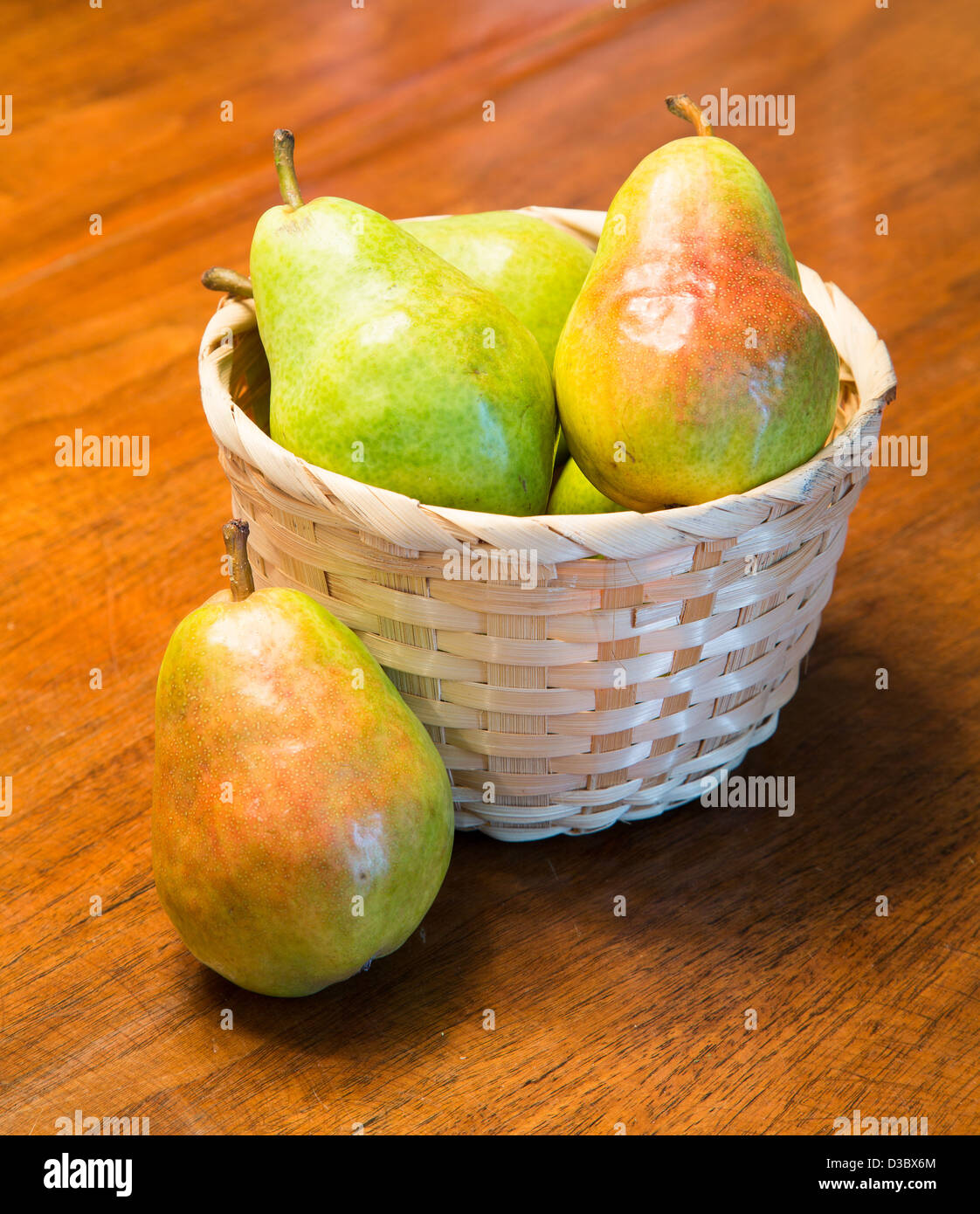 Fresh bartlett pears in a basket on a wood table Stock Photo
