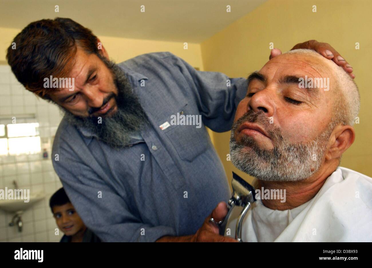 (dpa) - An Afghan man has his beard trimmed in a barber shop in Kabul, Afghanistan, 4 August 2003. Stock Photo