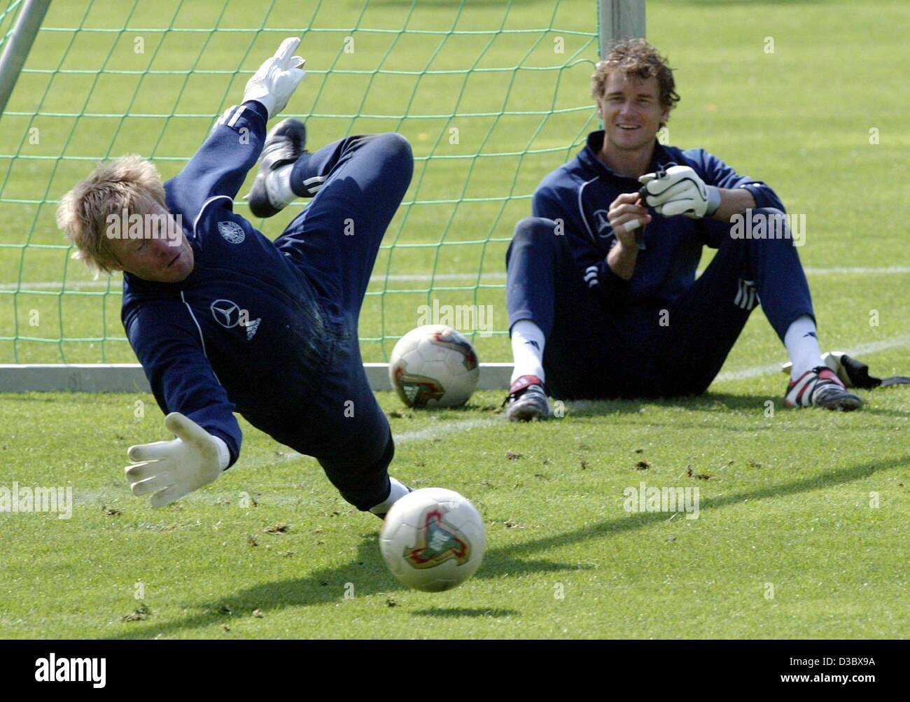(dpa) - German goalkeeper Jens Lehmann (R) watches his colleague Oliver Kahnn jumping to make a save during a training of the German soccer squad in Ostfildern-Ruit near Stuttgart, Germany, 18 August 2003. Germany faces Italy in a friendly game on Wednesday, 20 August. Stock Photo