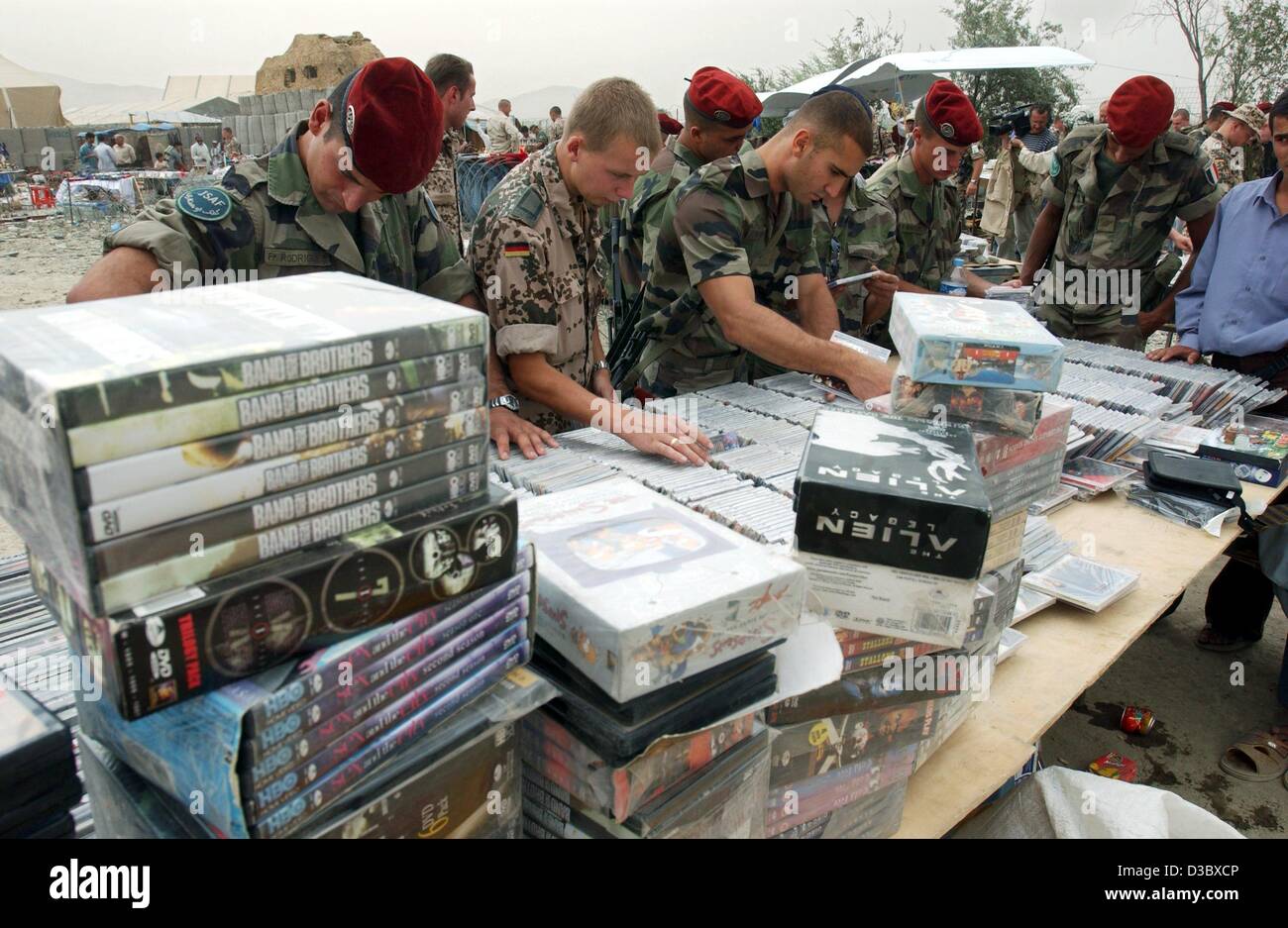 (dpa) - German soldiers look, in their spare time, through stacks of dvds, cds and other merchandise at the stands of street traders in Kabul, Afghanistan, 3 August 2003. Germany continues to participate with more than 1,500 soldiers in the International Securtiy Assistance Force (ISAF) which consis Stock Photo