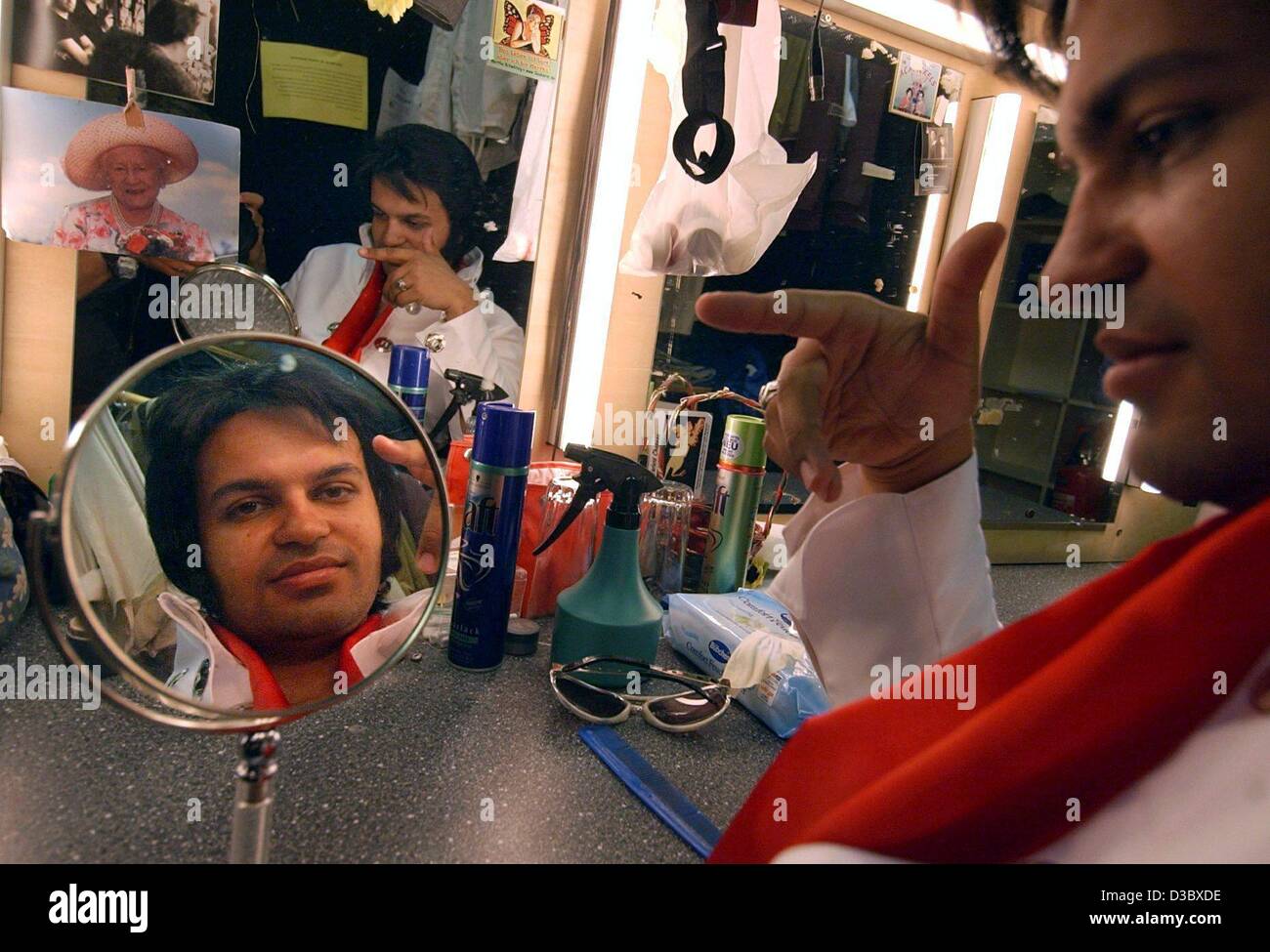 (dpa) - Elvis Presley impersonator Shelvis sits in his dressing room and looks in a small mirror while is image is reflected in the larger mirror in front of him at the 'Angies' nightclub in Hamburg, Germany, 12 August 2003. Shelvis will revive Elvis Presley in a pup on 16 August 2003, which is the  Stock Photo