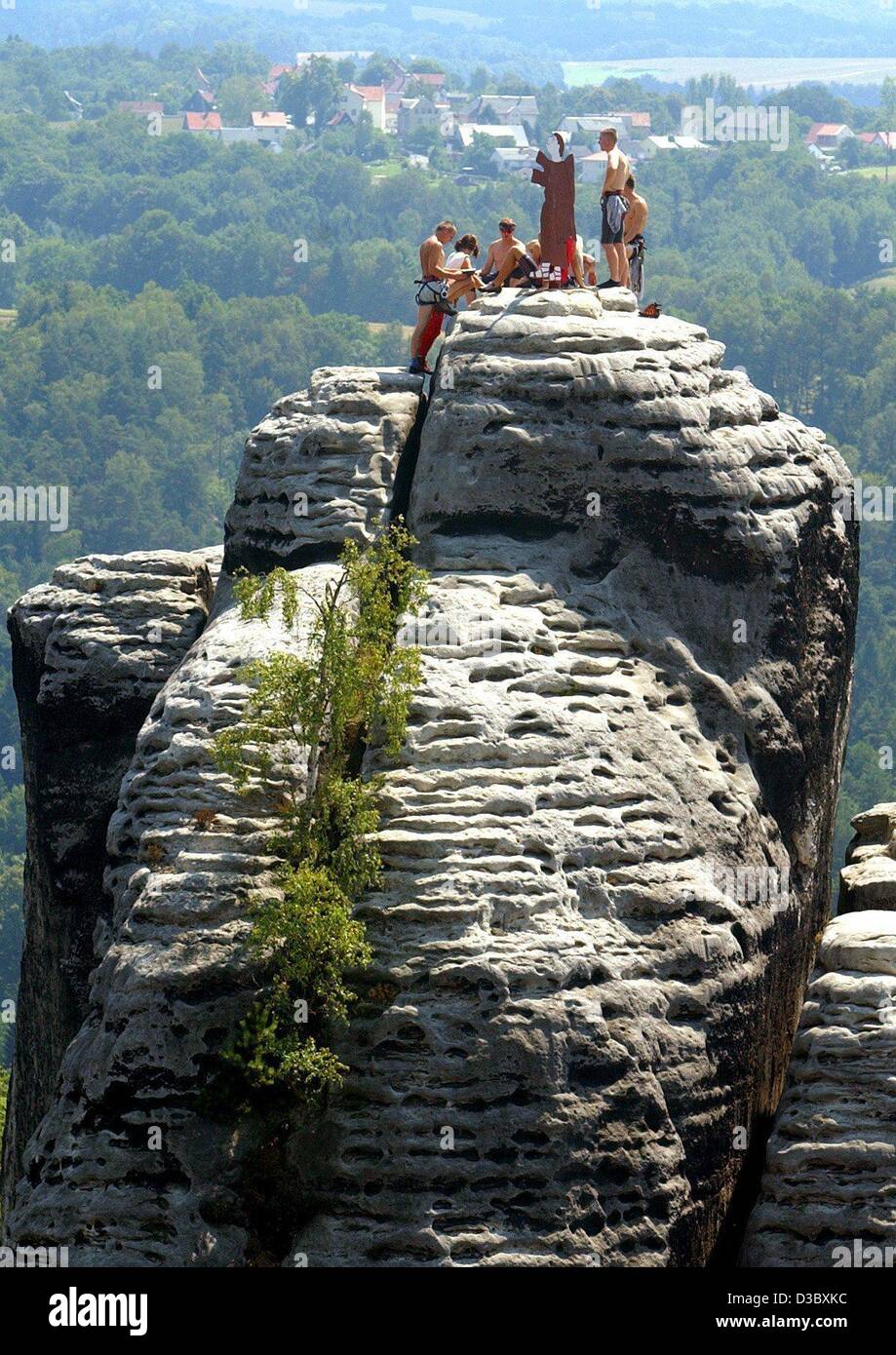 (dpa) - Free climbers sign a 'guest book' on top of the Moenchstein rock in the freeclimbing area of Rathen in Saxony, Germany, 19 July 2003. On each of the 1,099 peaks in the Saxonian Switzerland a book is hidden in a metal case in which everyone who made it to the top can sign his name. This year, Stock Photo