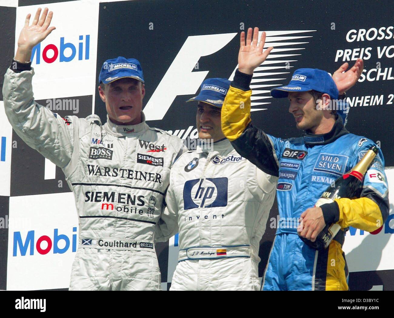 (dpa) - Colombian Juan Pablo Montoya of BMW-Williams (C) cheers on the podium after winning the Formula One Grand Prix of Germany at the Hockenheim race track in Hockenheim, Germany, 3 August 2003. On the left second placed David Coulthard from Scotland (McLaren-Mercedes) and third placed Jarno Trul Stock Photo