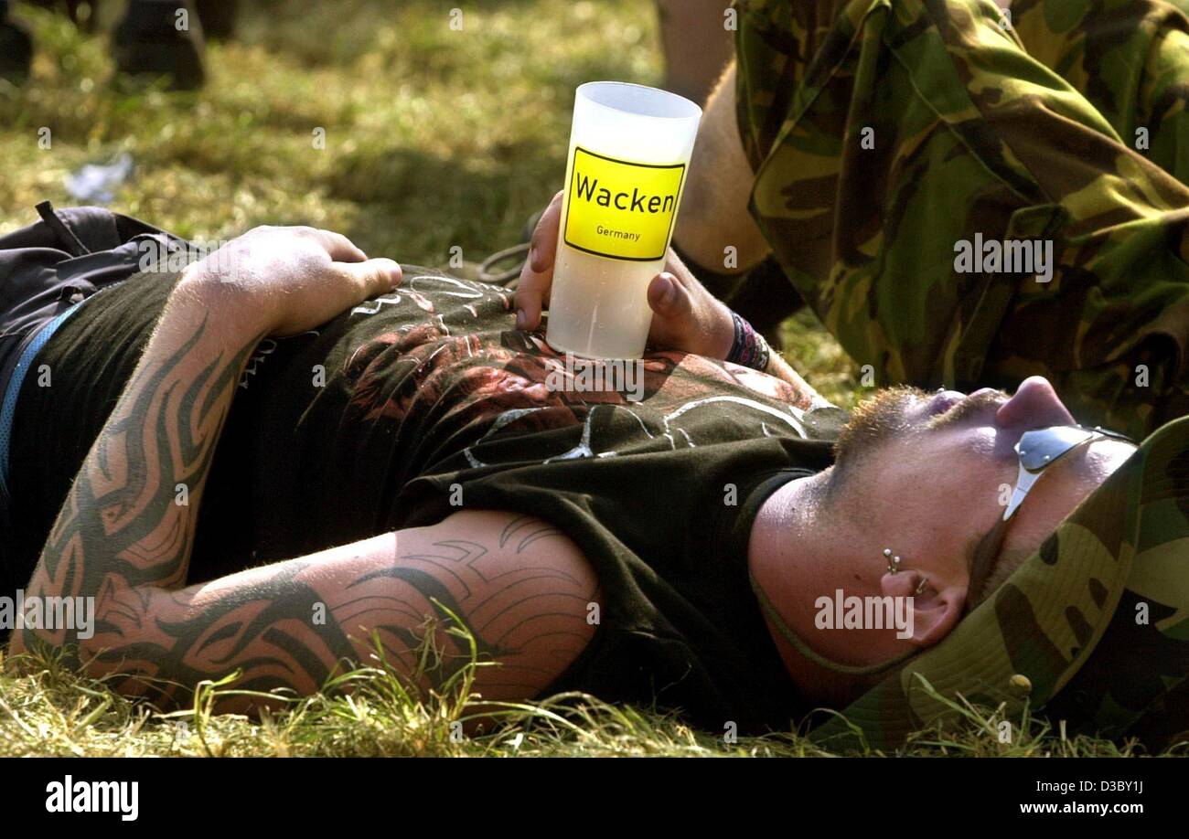 (dpa) - A heavy metal fan relaxes with a plastic cup on his chest at the 14th Wacken open air concert in Wacken, Germany, 1 August 2003. Stock Photo