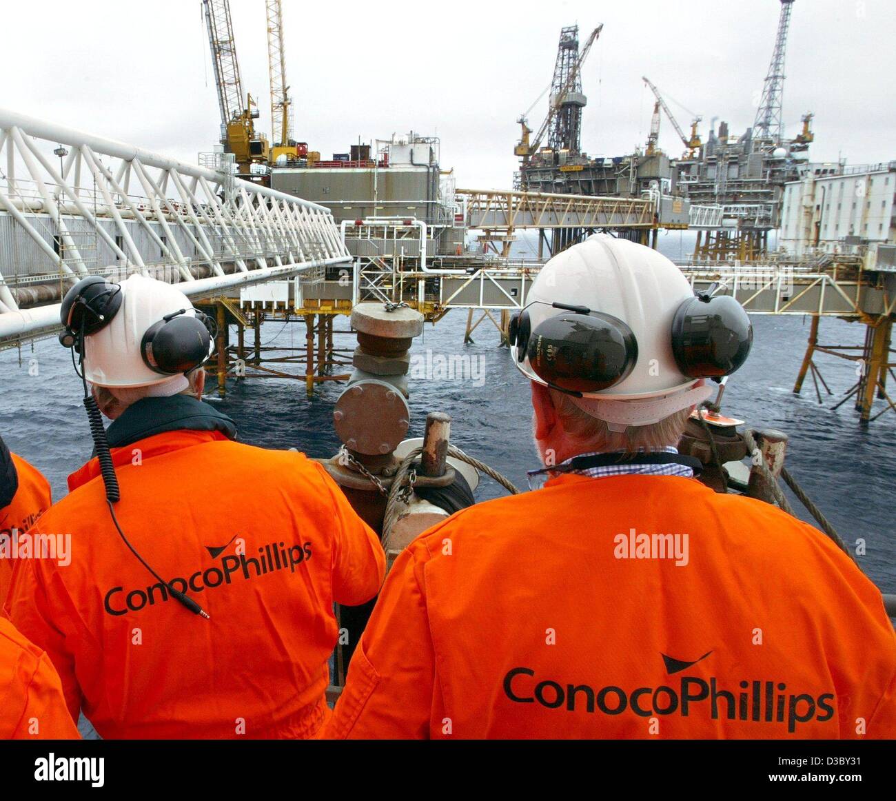 (dpa) - Workers stand on the gas and oil rig in the North Sea, about 250 km offshore of Stavanger, Norway, 5 July 2003. The platform belongs to the Ekofisk field complex, which comprises the oil and gas rigs Ekofisk, Eldfisk, Embla and Tor. The workers stay two weeks on the rig working 12 hour shift Stock Photo