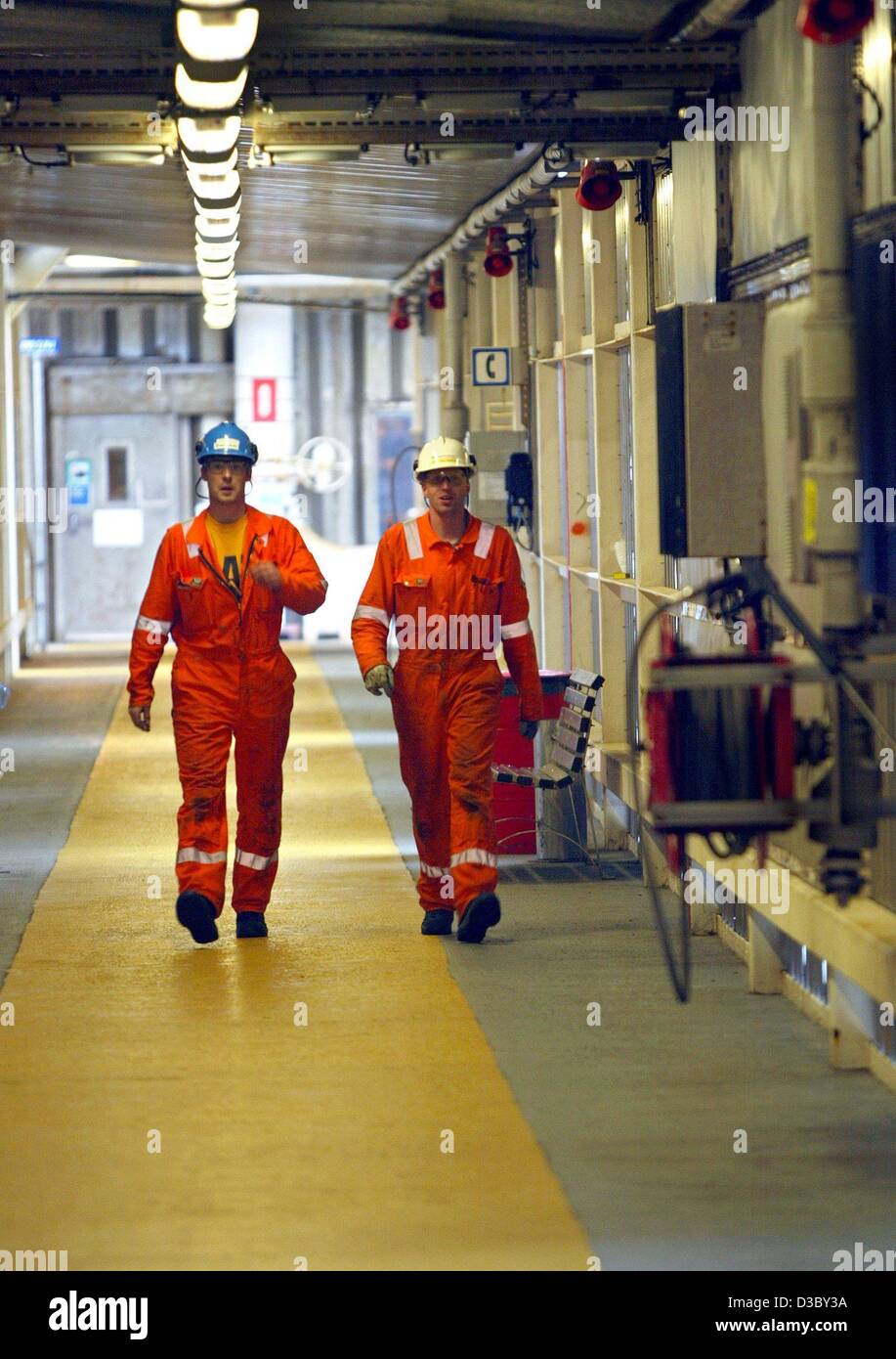 (dpa) - Workers walk through a connecting corridor on a gas and oil rig in the North Sea, about 250 km offshore of Stavanger, Norway, 5 July 2003. The platform belongs to the Ekofisk field complex, which comprises the oil and gas rigs Ekofisk, Eldfisk, Embla and Tor. The workers stay two weeks on th Stock Photo
