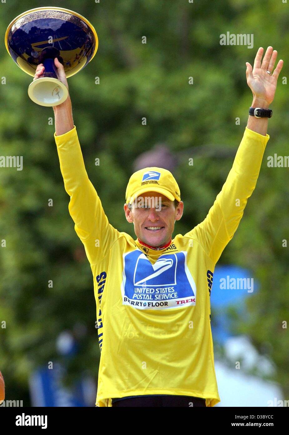 (dpa) - US Postal-Berry Floor's Lance Armstrong from the US, wearing the overall leader's yellow jersey, holds up the Tour de France 100th anniversary cup as he poses on the podium after the 20th stage of the 2003 Tour de France cycling race, in Paris, 27 July 2003. Armstrong became the second rider Stock Photo