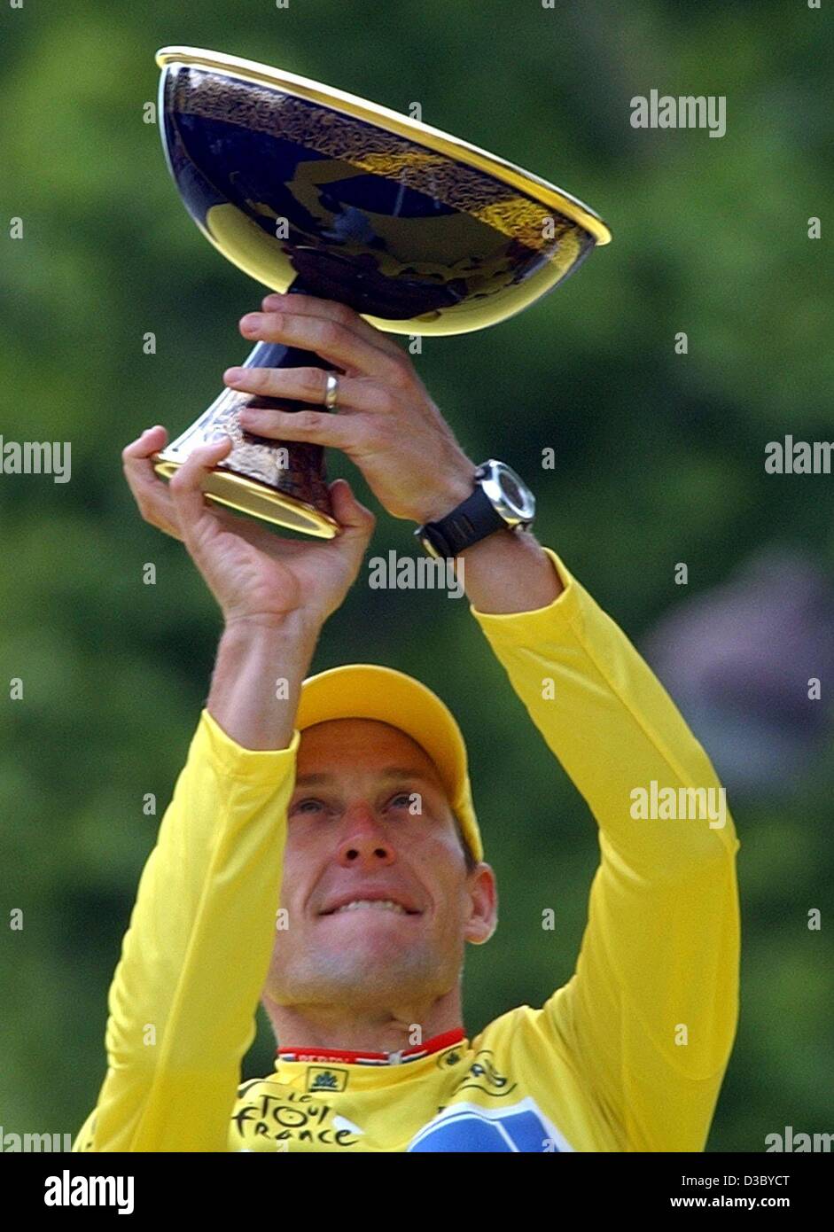 (dpa) -  US Postal-Berry Floor's Lance Armstrong from the US, wearing the overall leader's yellow jersey, holds up the Tour de France 100th anniversary cup as he poses on the podium after the 20th stage of the 2003 Tour de France cycling race, in Paris, 27 July 2003. Armstrong became the second ride Stock Photo
