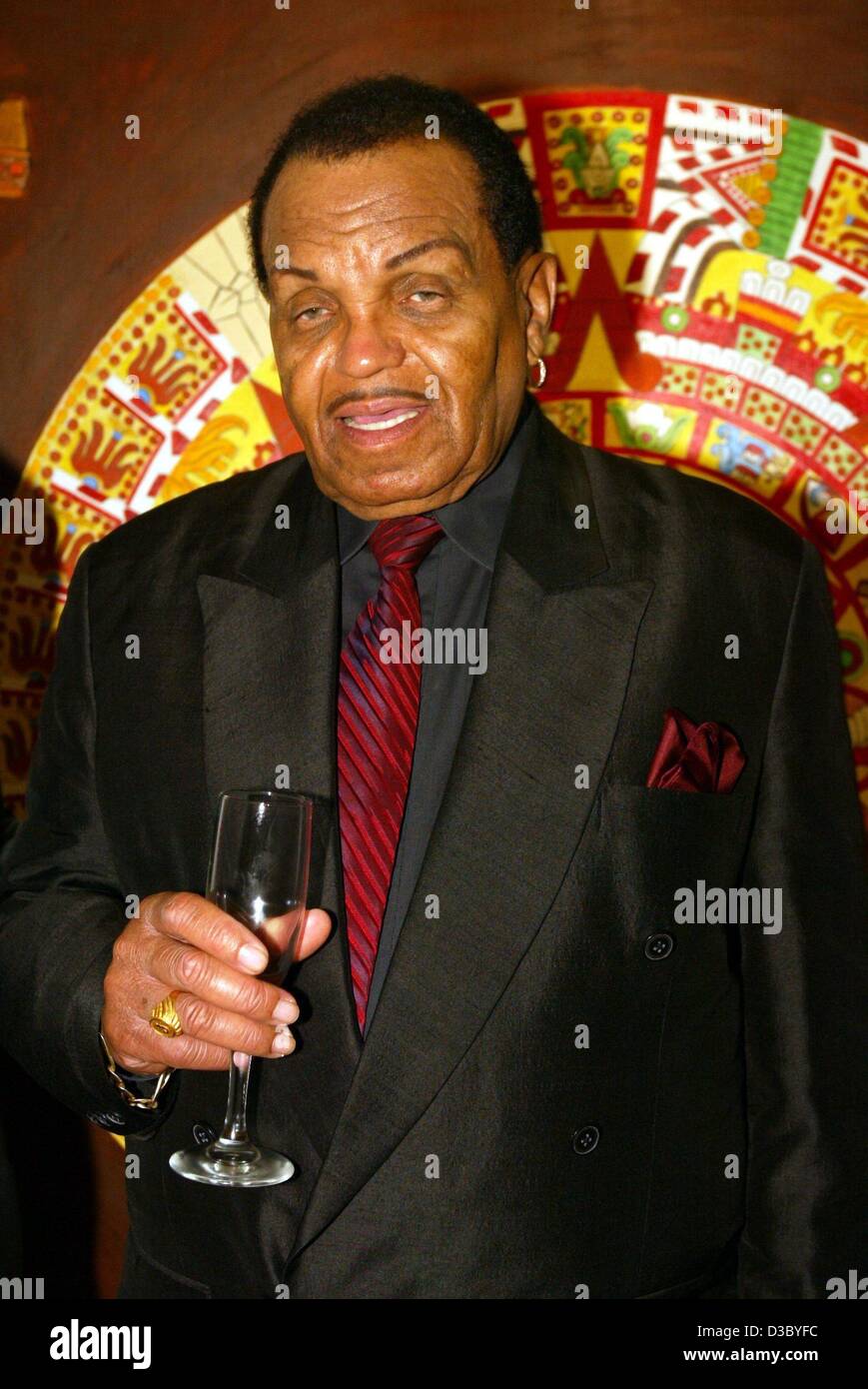 (dpa) - Joe Jackson stands with a glass of sparkling wine in a villa in Benedict Canyon, Hollywood/California, USA, 25 July 2003. The father of pop star Michael Jackson and founder of the legendary 'Jackson Five' celebrates here into his 75th birthday on 26 July. Only few celebrities attended the pa Stock Photo