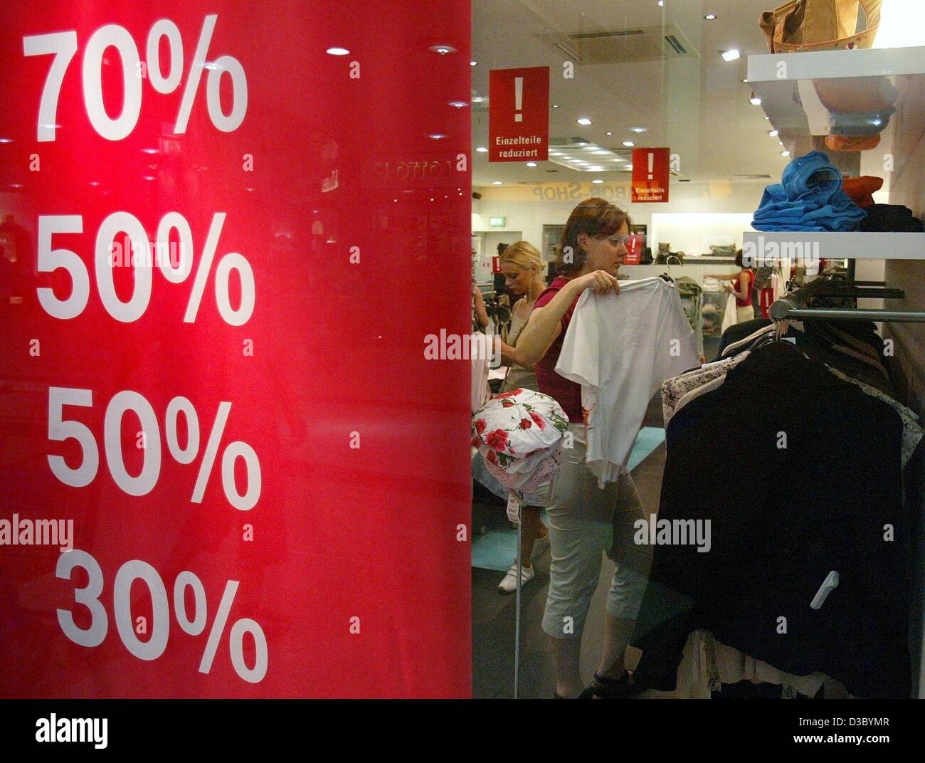(dpa) - The poster in the shopwindow showing the various per cents of discount aims at drawing customers into a clothes shop in Leipzig, Germany, 22 July 2003. Summer sales officially start on 28 July, but retailers now already offer discounts and reductions. Stock Photo