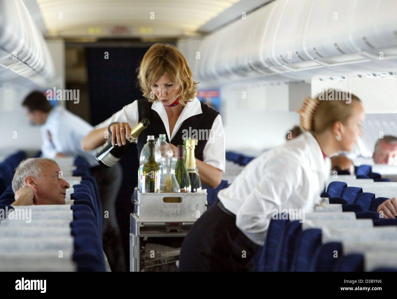 (dpa) - A stewardess of the Deutsche Lufthansa airline offers passengers a drink during a flight from Dessau, Germany, 17 July 2003. Stock Photo
