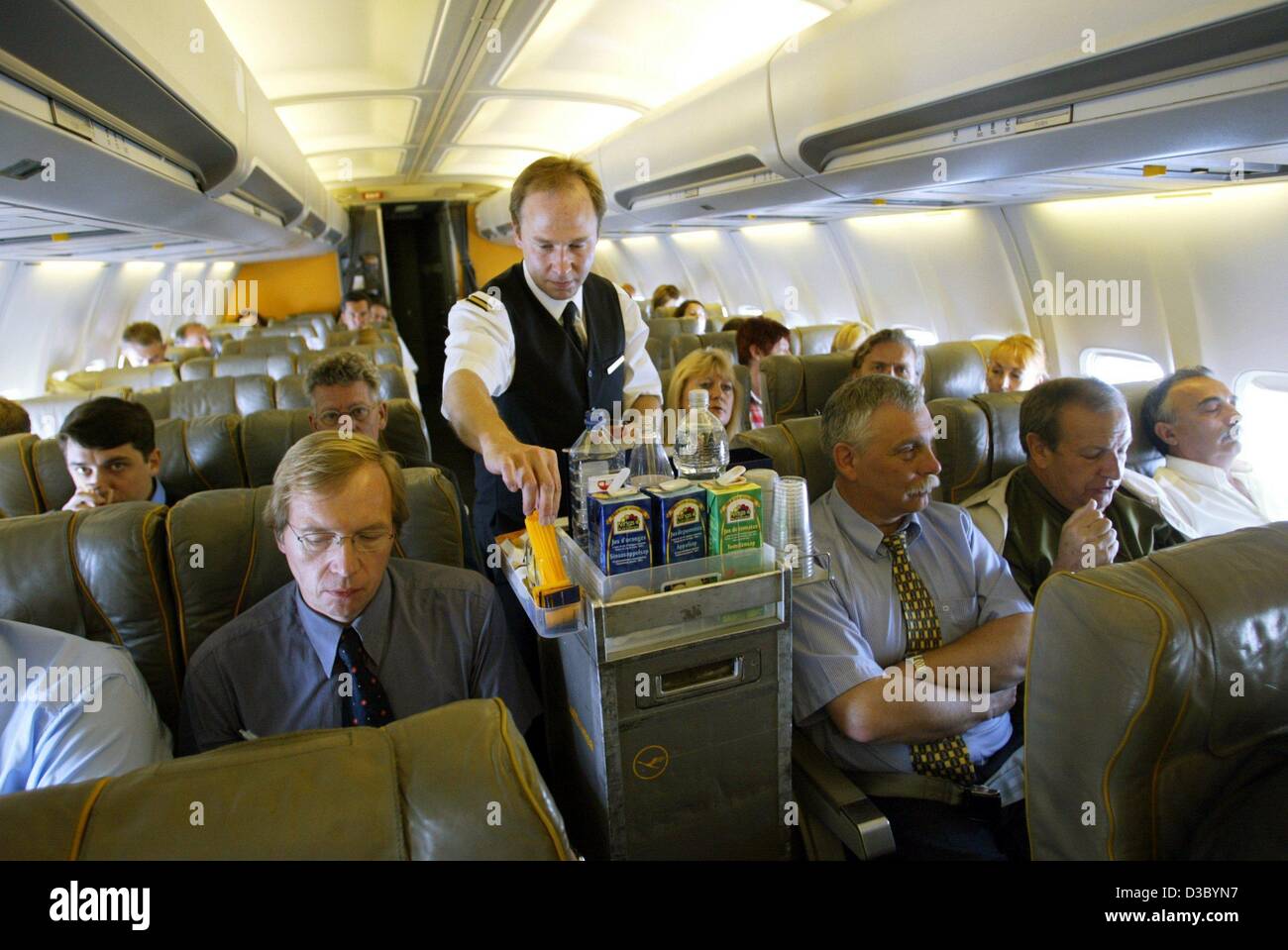 (dpa) - A steward of the Deutsche Lufthansa airline offers passengers a drink during a flight from Dessau, Germany, 17 July 2003. Stock Photo