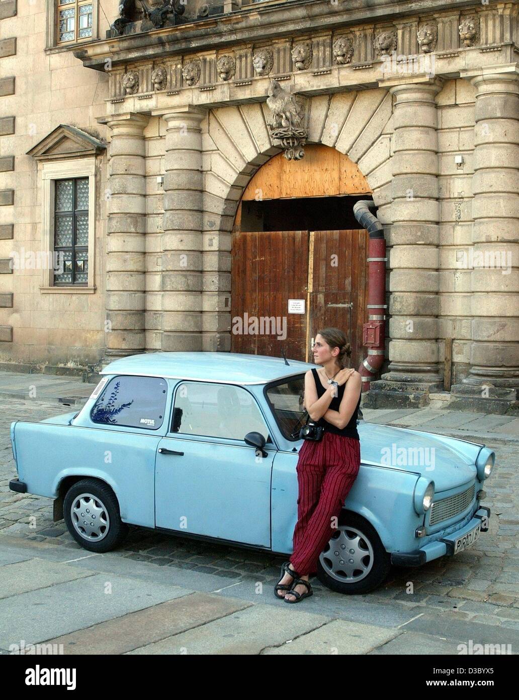 (dpa) - A young woman leans on a baby blue East German Trabant automobile, nicknamed 'Trabi' by the general public, in Dresden, eastern Germany, 20 July 2003. The little east German cars of the former GDR are still a favorite with car collectors and car fans. Stock Photo