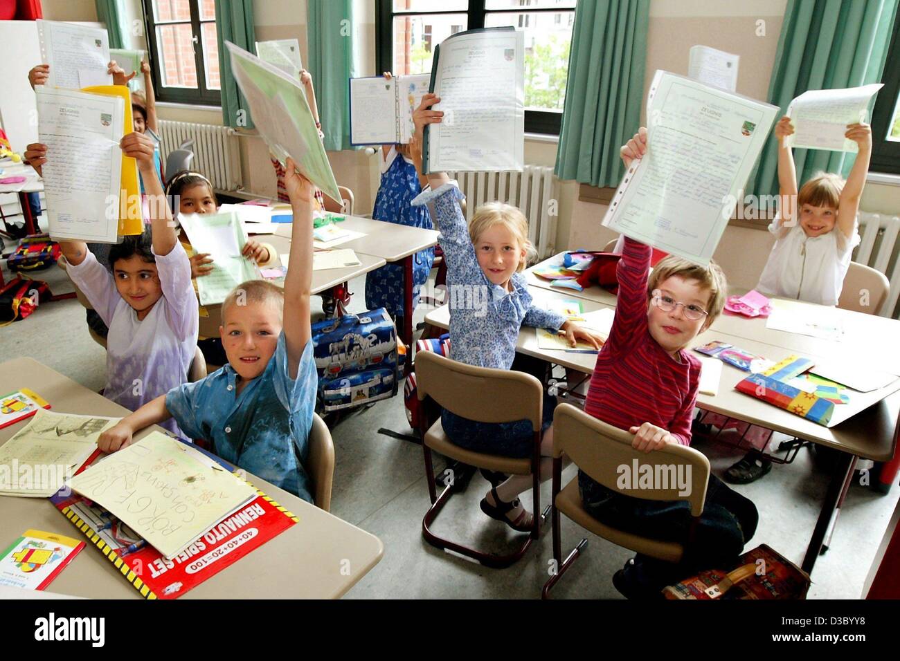 (dpa) - First graders proudly show their first end-of-year school reports at an elementary school in Magdeburg, Germany, 9 July 2003. The day was also the last day of school before the start of the summer holidays. Stock Photo