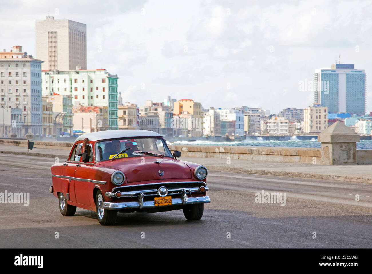 Old 1950s vintage American car / Yank tank driving along the El Malecón / Avenida de Maceo in Havana, Cuba, Caribbean Stock Photo
