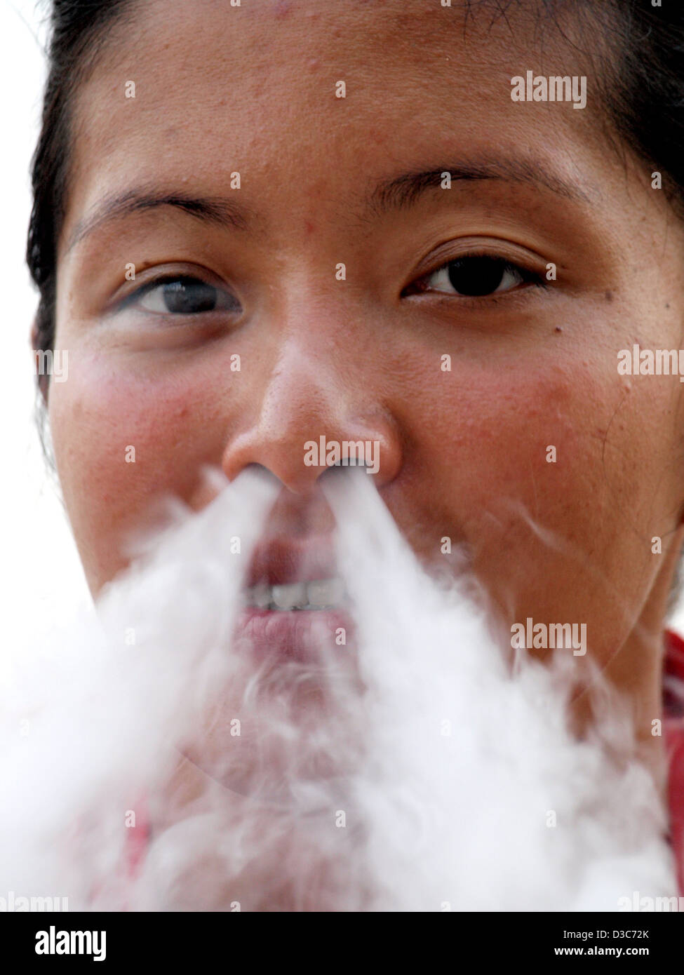 Woman blowing smoke out nose hi-res stock photography and images - Alamy