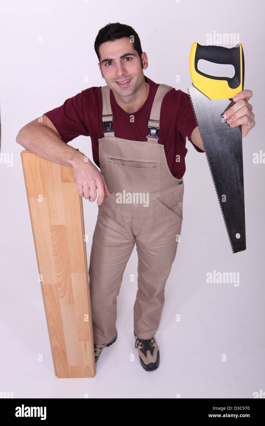 Craftsman with saw and wooden slat Stock Photo