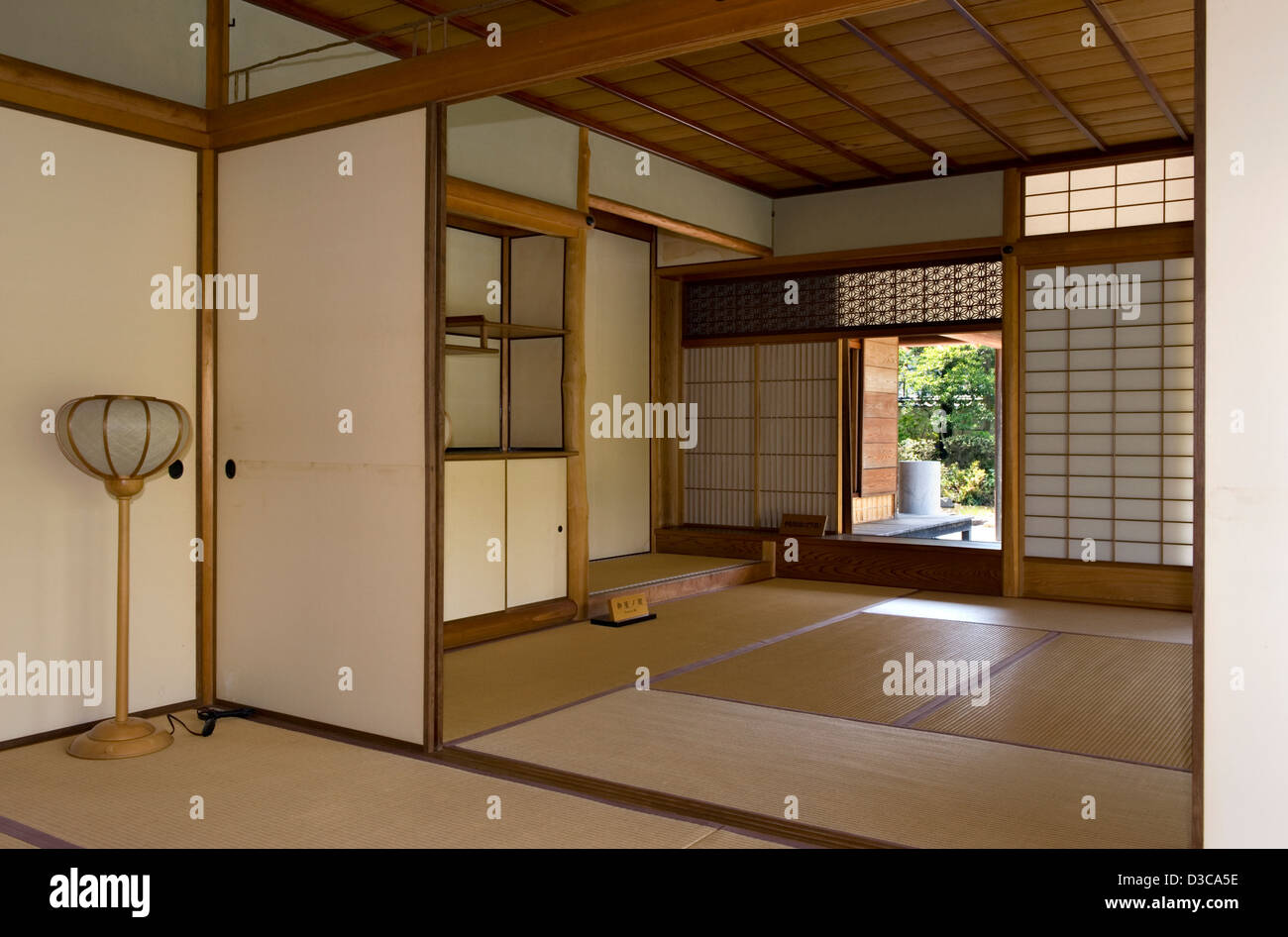 Natural warm wood tones, tatami mat floor and sliding shoji screens of traditional Japanese architecture in a residence interior Stock Photo