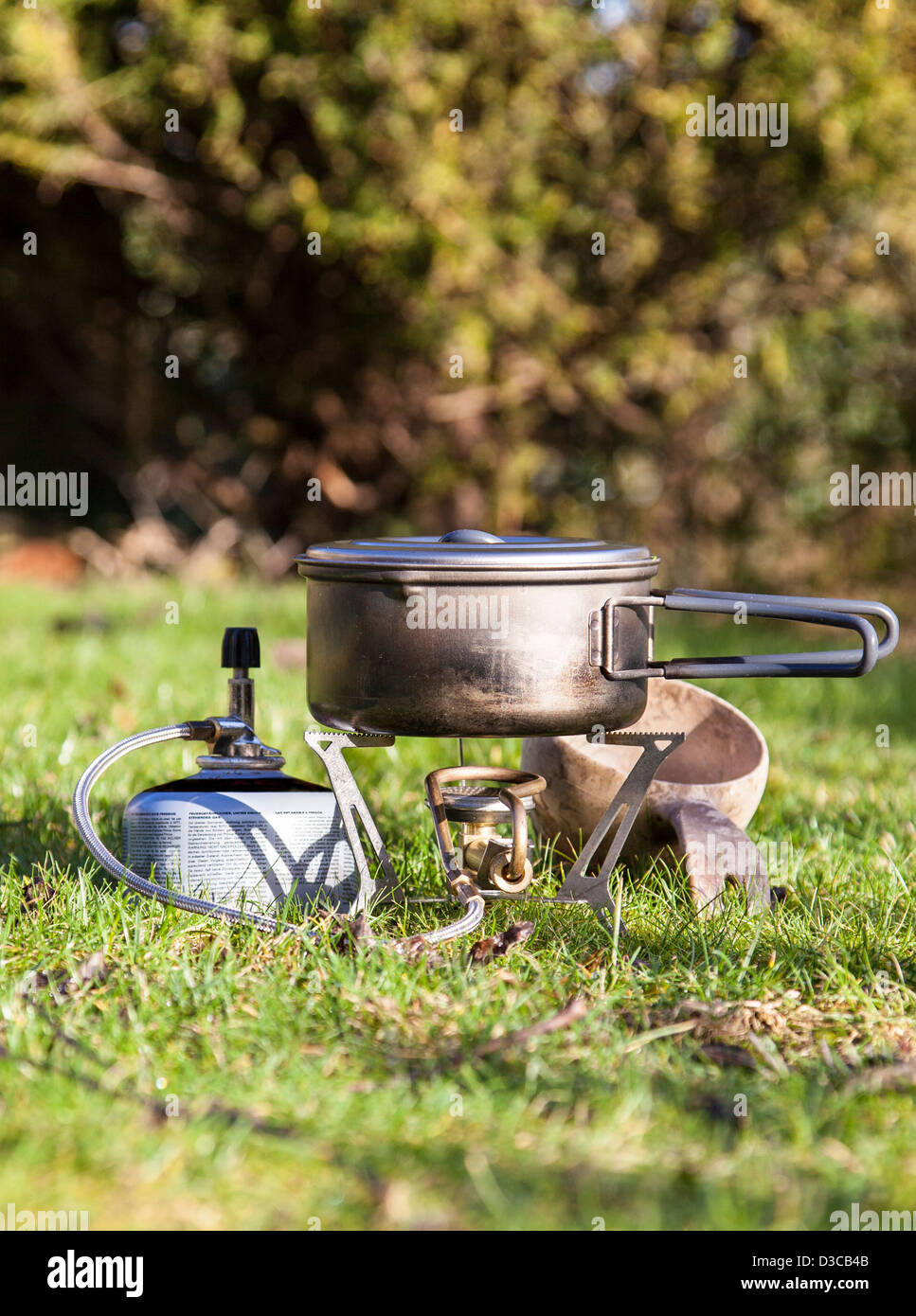 Camping Stove with Gas Canister and Wooden Mug Stock Photo