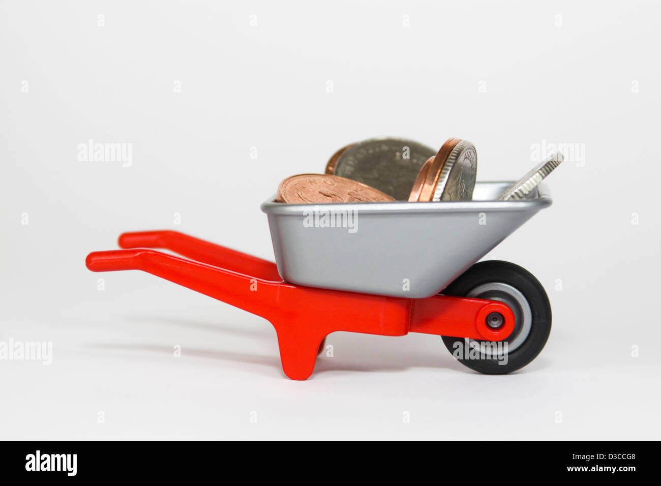 Coins in small plastic toy wheelbarrow Stock Photo Alamy