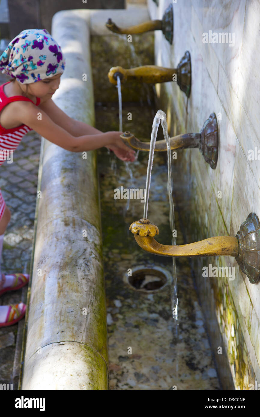 Bulgaria, Europe, Black Sea, Nessebar, Old Town, Young Girl Washing Her Hands At Public Water Taps. Stock Photo