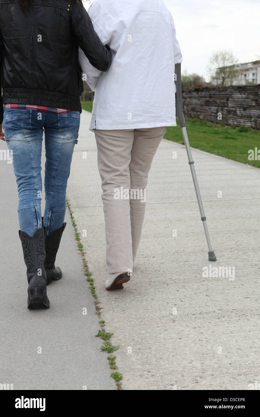 woman helping senior to walk Stock Photo