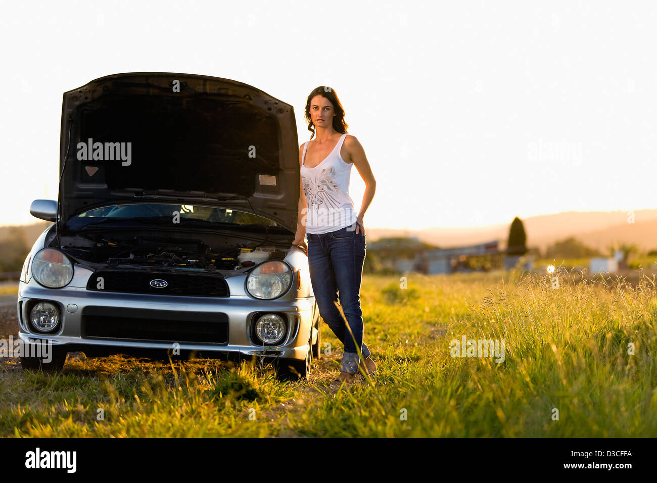 Woman standing with her broken down car Stock Photo