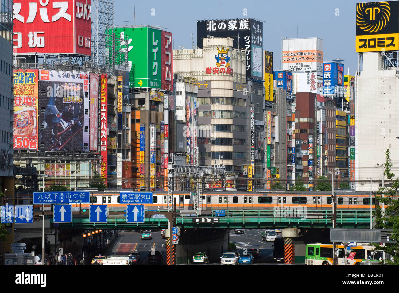 Cityscape skyline concrete jungle of buildings, signs, trains and cars in Kabuki-cho entertainment district East Shinjuku, Tokyo Stock Photo