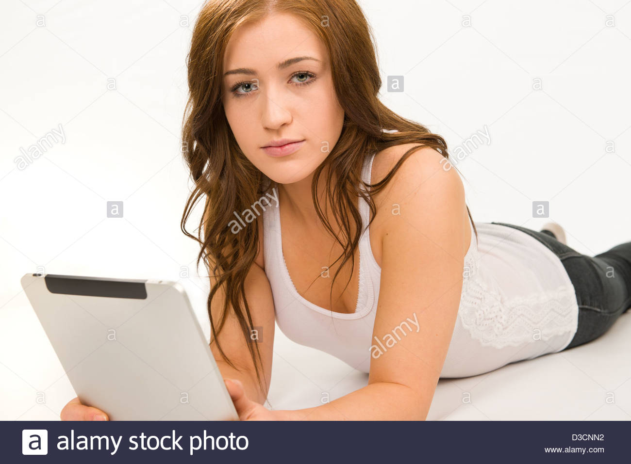 teen girl in a white tank top on a white background holding an Ipad Stock  Photo - Alamy