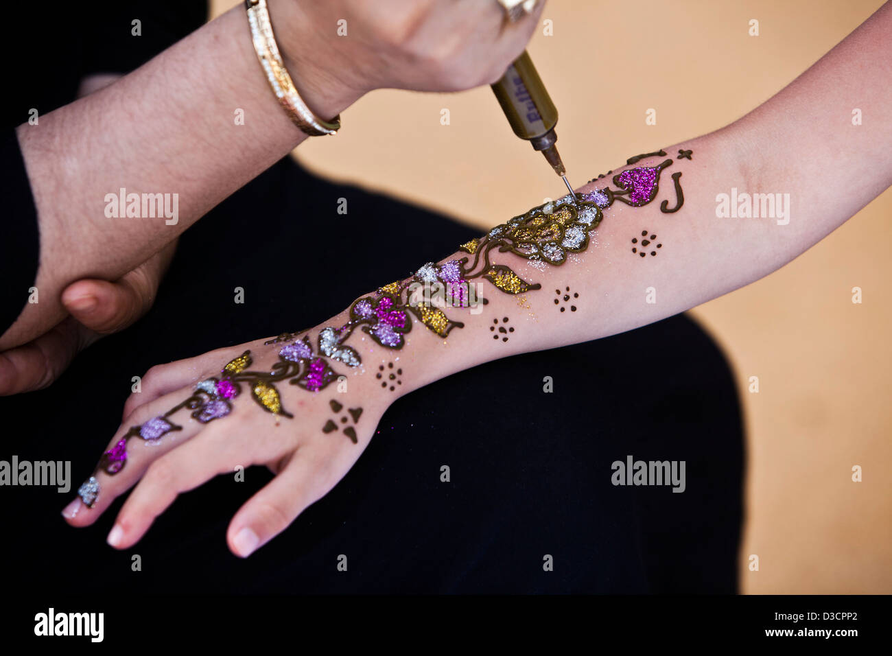Girl having tattoo on arm, Marrakech, Morocco Stock Photo